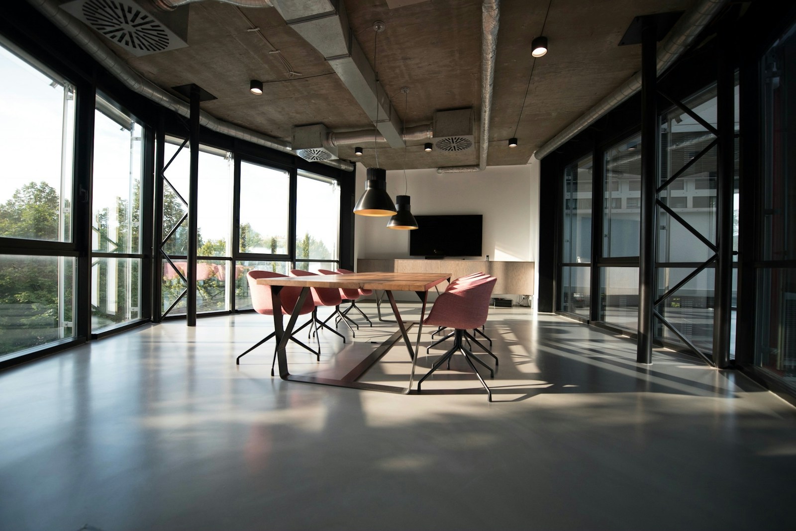 A bright, open workplace with natural light, plants, and shared tables